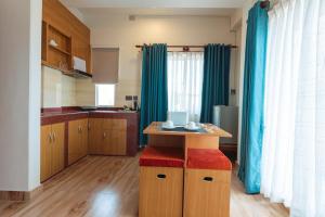 a kitchen with blue curtains and a wooden table at A Square Residency Inn in Pokhara