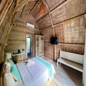 ein Schlafzimmer mit einem Bett und einer Bank in einem Zimmer in der Unterkunft The Lumbung Residence in Kerobokan + 18 Fotos
