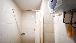 a bathroom with a shower with a shower curtain at Good Place Studio Apartment at Vida View Makassar By Travelio in Pampang +10 photos