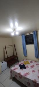 a bedroom with a bed and a window with blue curtains at Casa Campina in Carmo
