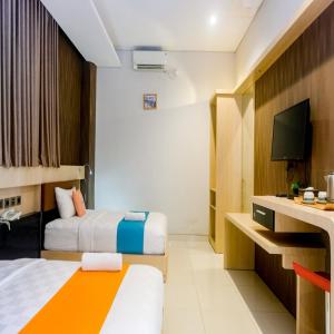 Postel nebo postele na pokoji v ubytování Sans Hotel Grand Omah Sastro Yogyakarta