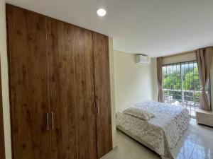 a bedroom with a bed and a large wooden cabinet at Espectacular casa con parqueadero bien ubicada in Barranquilla