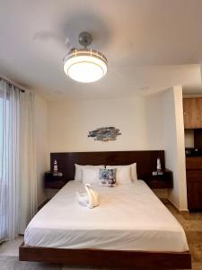プラヤ・デル・カルメンにあるItzamna Suite Balcony Deluxeのベッドルーム(ライト付きの白い大型ベッド1台付)