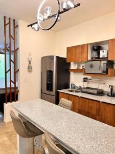 プラヤ・デル・カルメンにあるItzamna Suite Balcony Deluxeのテーブルと冷蔵庫のあるキッチン