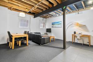a living room with a couch and a table at Gibson Mill waterfront warehouse apartment - 102 in Hobart