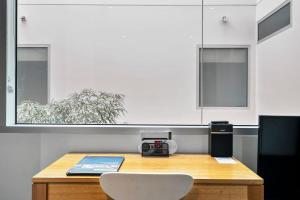 a kitchen with a wooden table with a white chair at Gibson Mill waterfront warehouse apartment - 104 in Hobart