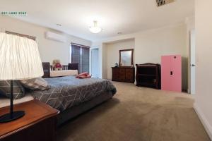 - une chambre avec un lit et un réfrigérateur rose dans l'établissement Balwyn Luxury 5BR Mansion with Cinema & BBQ, à Melbourne