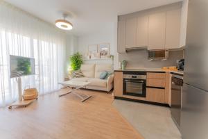 une cuisine et un salon avec un canapé et une table dans l'établissement Brisa de Levante By Martina Suites, à El Altet