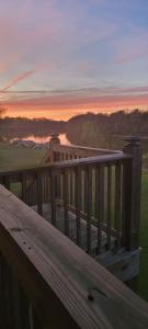 a wooden deck with a sunset in the background at Waterfront Bama Getaway-20 min to UA in Englewood