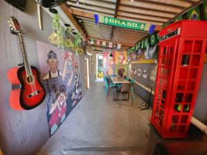 a room with a red phone booth and a table with a guitar at Vila Rock Hostel - próximo Allianz Parque, Vila Madalena, Av Paulista, Hospital das Clínicas INCOR FMUSP in São Paulo