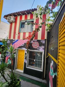a building with a yellow door and a painting on it at Vila Rock Hostel - próximo Allianz Parque, Vila Madalena, Av Paulista, Hospital das Clínicas INCOR FMUSP in São Paulo
