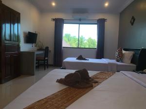 a hotel room with two beds and a window at Sakun House in Siem Reap