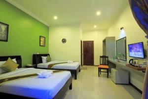 a hotel room with two beds and a desk at Sakun House in Siem Reap
