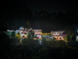 un edificio de noche con sus luces encendidas en Mountain Hut Vattavada Resort, en Munnar 10 fotos más