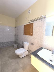 un baño con inodoro y lavabo en Mountain Hut Vattavada Resort, en Munnar