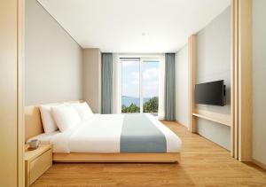 a hotel room with a bed and a window at Hanwha Resort Geoje Belvedere in Geoje  +17 photos