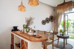 een eetkamer met een houten tafel en stoelen bij Casa Nebula Villa in Kerobokan