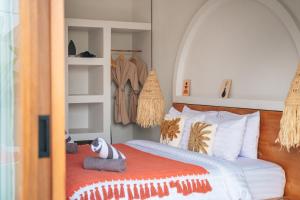 een slaapkamer met een bed met een oranje deken bij Casa Nebula Villa in Kerobokan +10 foto's