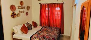 a bedroom with a bed with a red curtain at Blue Eye Hostel in Jaisalmer +184 photos