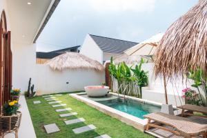 een kleine achtertuin met een zwembad en gras bij Casa Nebula Villa in Kerobokan