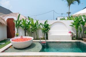 een bad naast een zwembad bij Casa Nebula Villa in Kerobokan