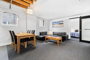 a living room with a couch and a table at Gibson Mill waterfront warehouse apartment - 202 in Hobart
