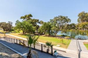 a park with a fence and a body of water at Hip Condo on Maribyrnong River Cityscape Views! in Melbourne