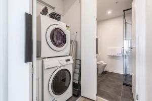 a washer and dryer in a room with a bathroom at Hip Condo on Maribyrnong River Cityscape Views! in Melbourne +26 photos