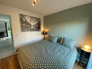 ein Schlafzimmer mit einem Bett und einem Bild an der Wand in der Unterkunft Bella Vie, rust en ontspanning in Haacht