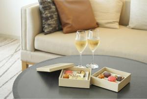 two glasses of wine and a box of food on a table at The Prince Kyoto Takaragaike, Autograph Collection in Kyoto