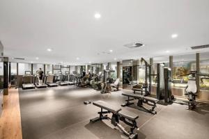 ein Fitnessstudio mit vielen Laufbändern und Geräten in der Unterkunft West Side Spencer St Apt w Marvel Stadium View in Melbourne