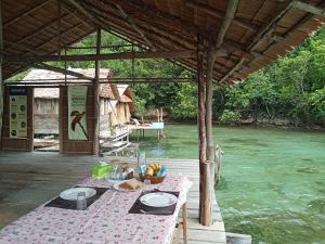 a table with plates of food on a table next to a river at Pin Wawiyai Natural Homestay in Yennanas Besir