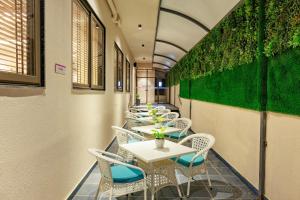 a row of tables and chairs with green walls at Regenta Place Jaipur Sirsi Road, Jaipur in Jaipur