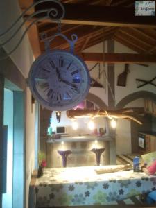 a clock hanging over a table in a room at De Baixo Da Ponte in Biscoitos