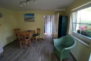 a dining room with a table and chairs and a window at Ferienwohnung bei Antje Timm in Hiddensee