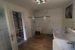 a bathroom with a tub and a shower and a sink at Ferienwohnung bei Antje Timm in Hiddensee