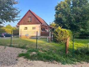 a fence in front of a house with a barn at Chata Rožany in Šluknov +10 photos