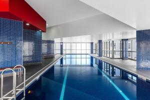 a large swimming pool with blue tiled walls and blue tiles at Cloud 17 Retreat - Meriton Soleil Private Apt 1B in Brisbane