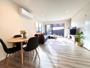 a living room with a table and a couch at CBD Luxury Parkside Living 2 Bedroom With Parking in Christchurch