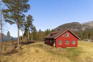 a red house in the middle of a field at Storhytta - 16p - Norwegian nostalgia by the water in Vradal