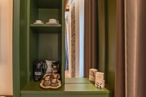 einem grünen Schrank mit einem Teller Essen auf einem Regal in der Unterkunft Ora Acanfora Suites in Rom + 45 Fotos