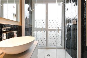 a bathroom with a large white tub and a shower at Locanda Carolina Mastino Scala in Sirmione +21 photos