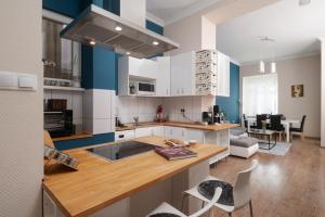 a kitchen with blue and white cabinets and a table at D17 Apartment in Budapest