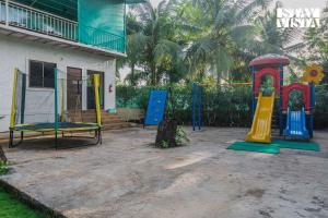 a playground in front of a house at Sundream Palms by VEO - Part of StayVista with Pool, Lawn, BBQ in Alibag
