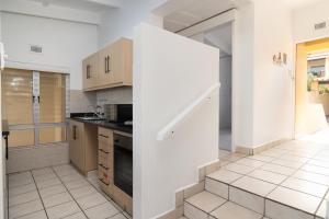 una cucina con pareti bianche e una scala al suo interno di Chakas Rock Chalets 49 a Ballito