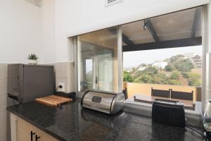 una cucina con bancone e una grande finestra di Chakas Rock Chalets 49 a Ballito