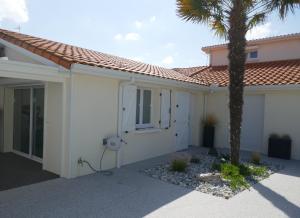 a house with a palm tree in front of it at Gîte 2 pers en studio indépendant chez l'habitant pour nuitée au calme et proche de la plage in Saint-Georges-de-Didonne
