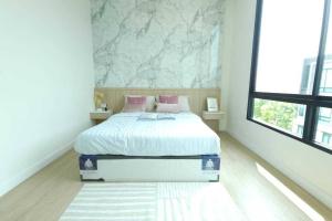 a bedroom with a white bed with pink pillows at The Pearl Residence House-At least 2 months in Bang O