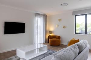 a living room with a couch and a tv at The Corner on Te Mata in Havelock North