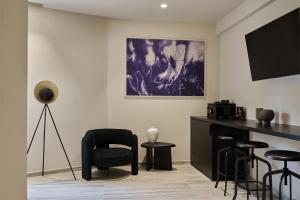 a living room with a chair and a tv at VISION Top Floor Apartments in Athens +20 photos